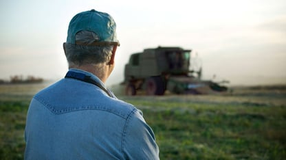 Mand der kigger på en mark og traktor